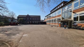 Schulhof, Hauptgebäude (rechts), Altbau (Bildmitte) mit OGS und Schülerbibliothek